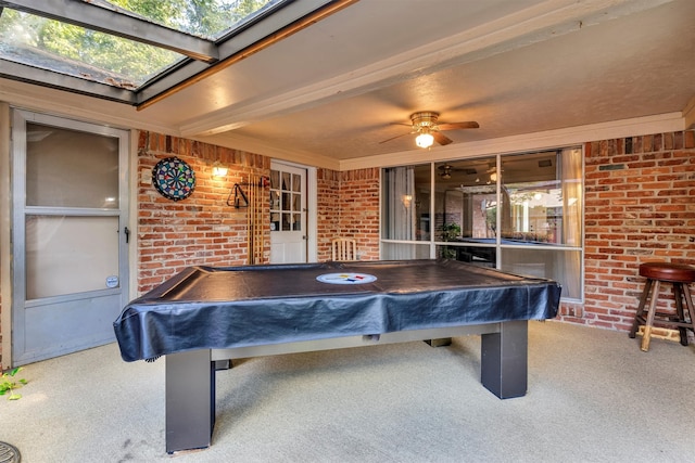 playroom featuring pool table, carpet flooring, a skylight, ceiling fan, and brick wall