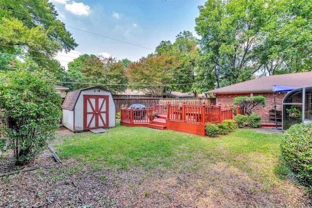 view of yard featuring a wooden deck and a storage unit