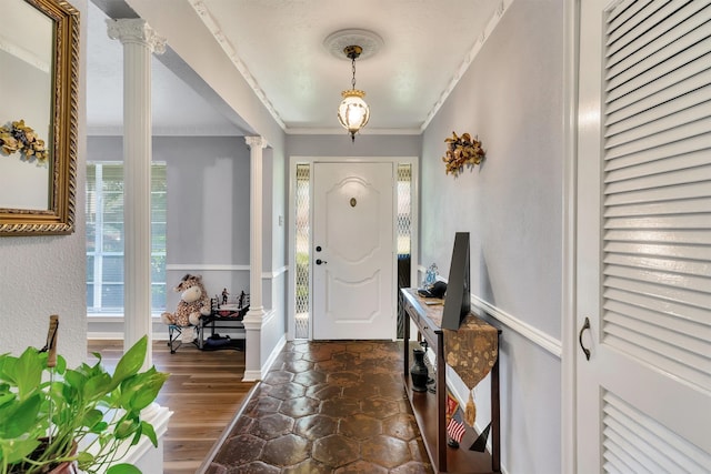 foyer featuring decorative columns, ornamental molding, and dark hardwood / wood-style floors