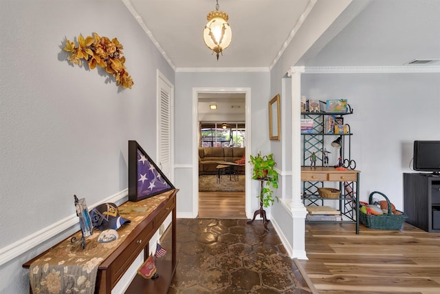 entrance foyer featuring decorative columns, dark wood-type flooring, and crown molding