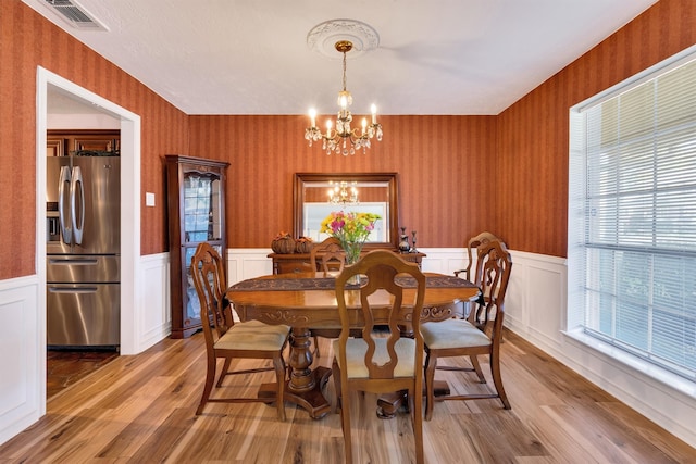 dining space with a notable chandelier and light wood-type flooring