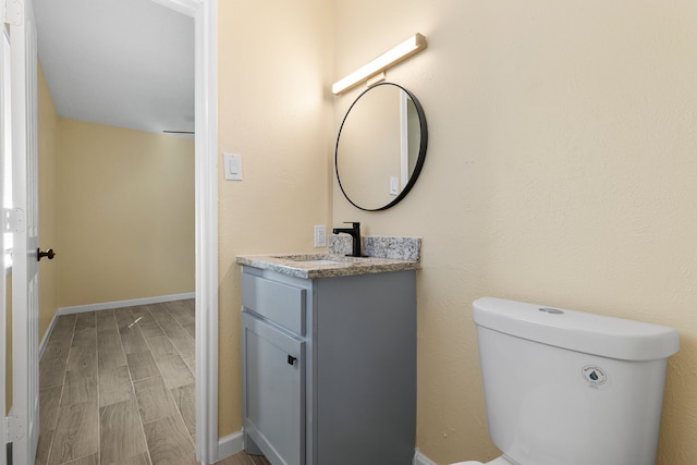 bathroom featuring wood-type flooring, vanity, and toilet