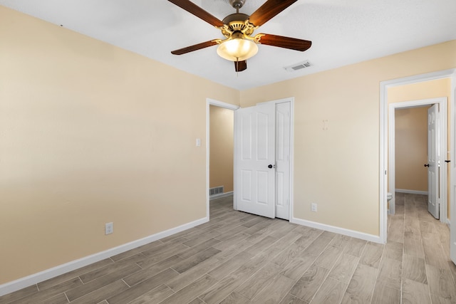 unfurnished bedroom with light hardwood / wood-style flooring, a closet, and ceiling fan