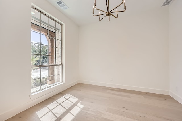 unfurnished dining area featuring light hardwood / wood-style floors and a chandelier