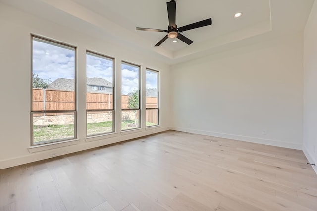 unfurnished room with ceiling fan, a wealth of natural light, and light wood-type flooring