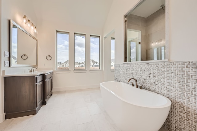 bathroom featuring separate shower and tub, tile patterned floors, vaulted ceiling, tile walls, and vanity