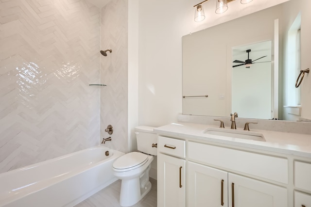 full bathroom featuring vanity, tiled shower / bath combo, toilet, and ceiling fan