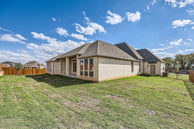 back of house featuring a yard and central AC