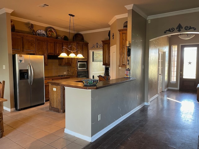 kitchen featuring kitchen peninsula, wood counters, ornamental molding, stainless steel appliances, and decorative light fixtures