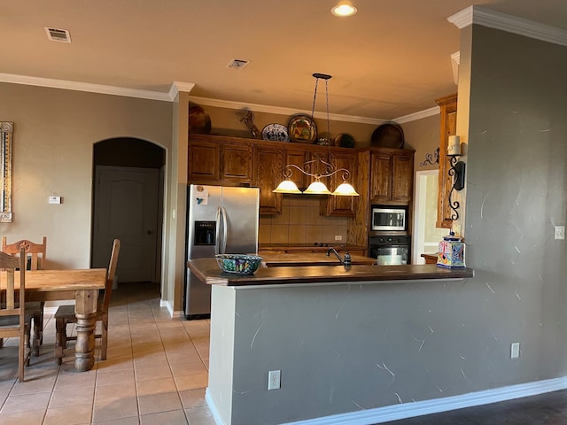 kitchen with pendant lighting, crown molding, light tile patterned floors, appliances with stainless steel finishes, and kitchen peninsula