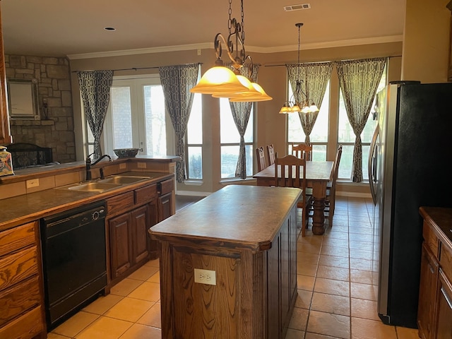 kitchen with pendant lighting, dishwasher, sink, a kitchen island, and stainless steel refrigerator