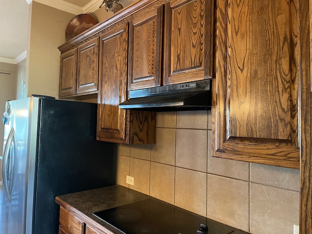 kitchen featuring tasteful backsplash, stainless steel fridge, cooktop, and ornamental molding