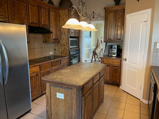 kitchen with pendant lighting, light tile patterned flooring, backsplash, appliances with stainless steel finishes, and a kitchen island