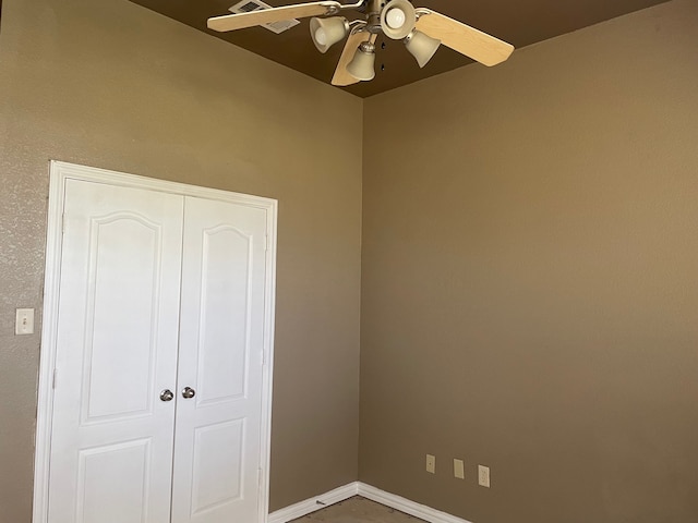 unfurnished bedroom with ceiling fan and a closet