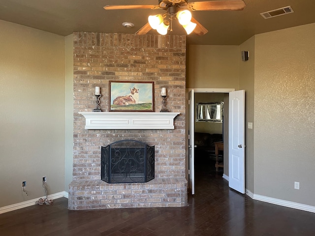 unfurnished living room featuring a brick fireplace, ceiling fan, and dark wood-type flooring