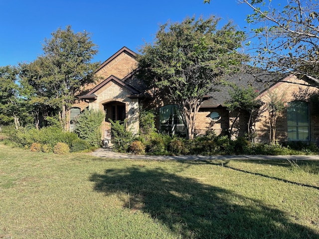 view of property hidden behind natural elements featuring a front lawn