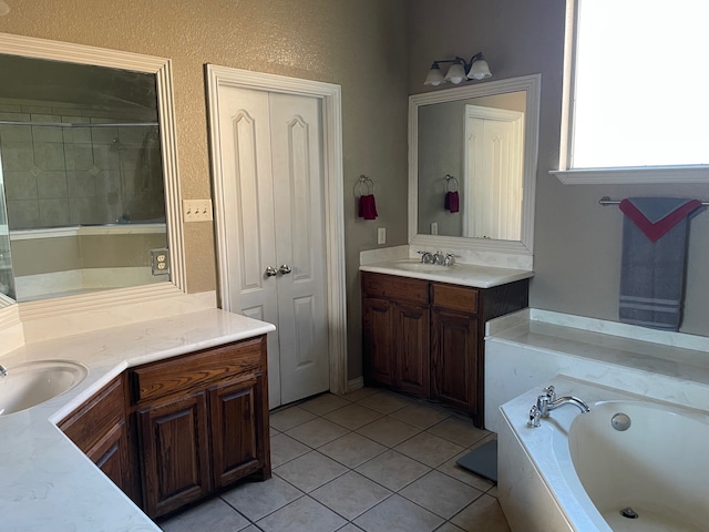 bathroom with tile patterned flooring, vanity, and a washtub