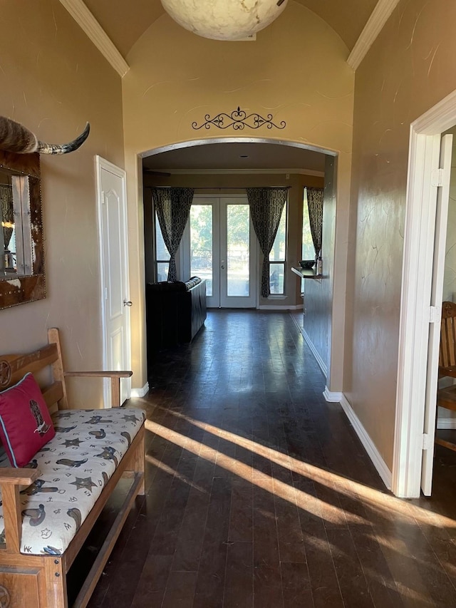 hallway with ornamental molding, dark wood-type flooring, high vaulted ceiling, and french doors