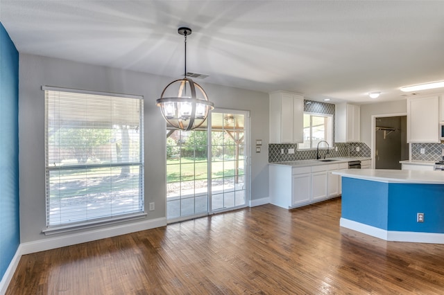 kitchen with dark wood-type flooring, decorative backsplash, decorative light fixtures, and white cabinetry