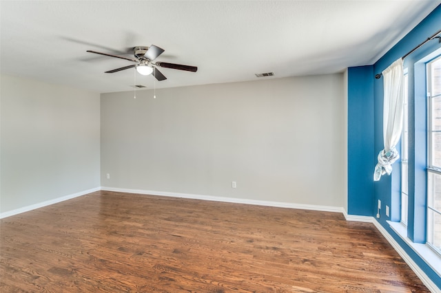 unfurnished room with dark wood-type flooring, ceiling fan, and a healthy amount of sunlight