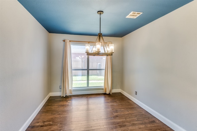 unfurnished dining area featuring plenty of natural light, an inviting chandelier, and dark hardwood / wood-style flooring