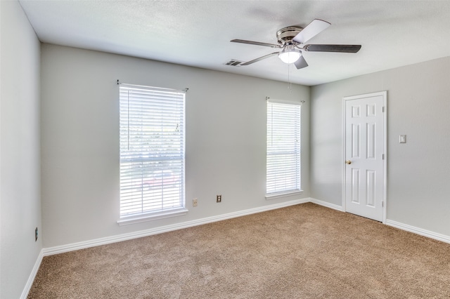 carpeted spare room with ceiling fan and a textured ceiling