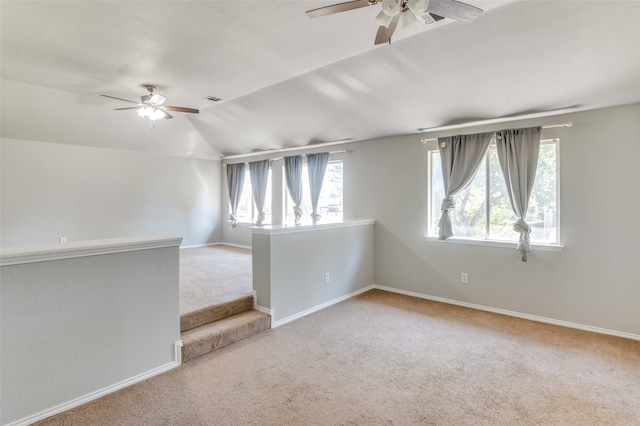 unfurnished room with ceiling fan, plenty of natural light, vaulted ceiling, and carpet