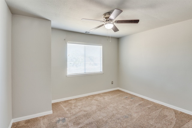 unfurnished room with light carpet, ceiling fan, and a textured ceiling