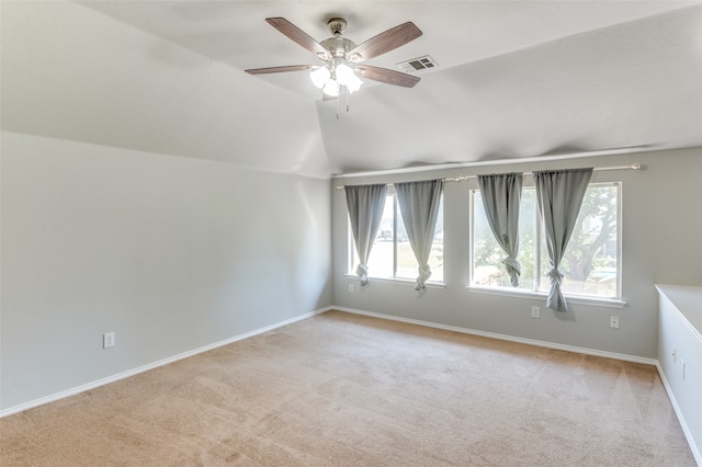 additional living space featuring light carpet, vaulted ceiling, and a healthy amount of sunlight