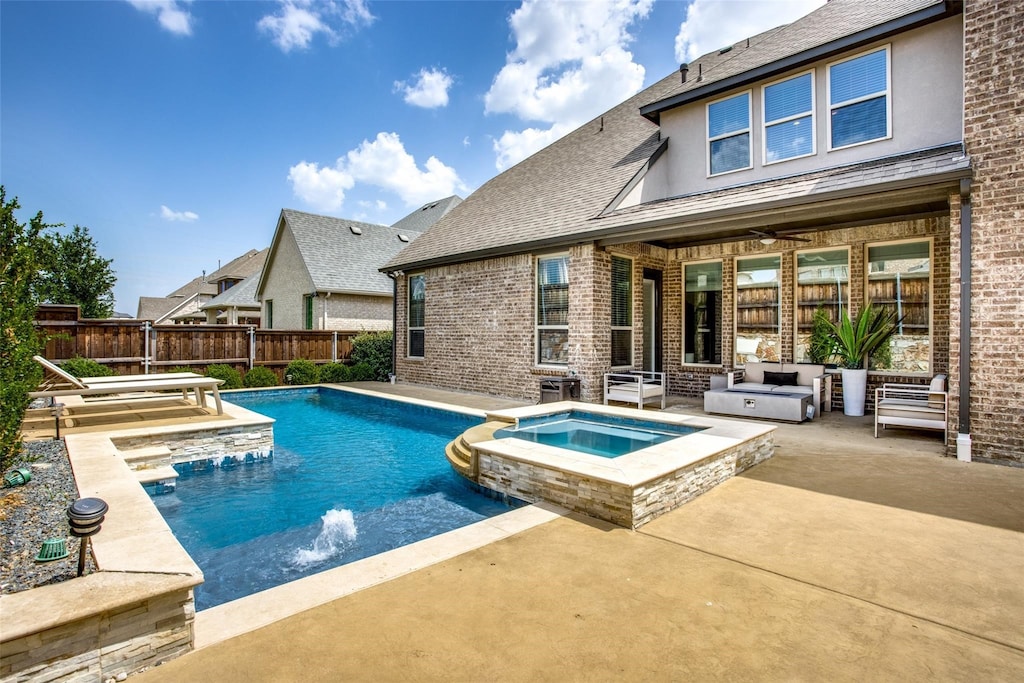 view of swimming pool with ceiling fan, an in ground hot tub, pool water feature, and a patio area