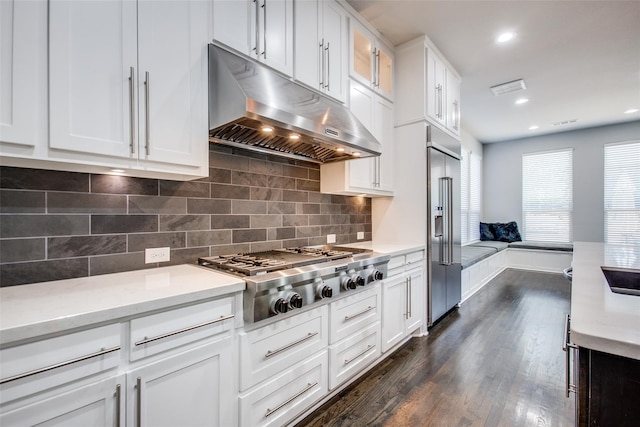 kitchen featuring white cabinetry, appliances with stainless steel finishes, dark wood-type flooring, and tasteful backsplash