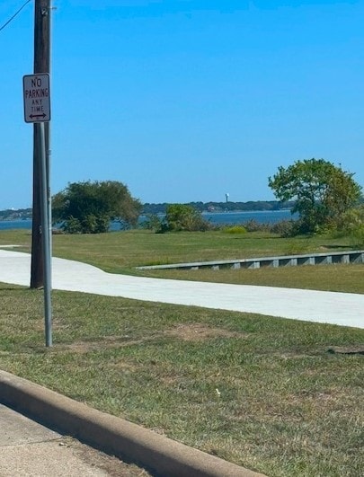 surrounding community with a lawn and a water view