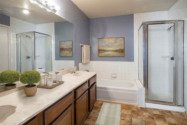 bathroom with independent shower and bath, vanity, and tile walls