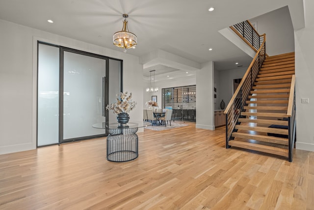 entrance foyer featuring light hardwood / wood-style flooring and a notable chandelier