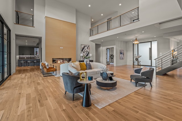 living room with a towering ceiling and light hardwood / wood-style floors