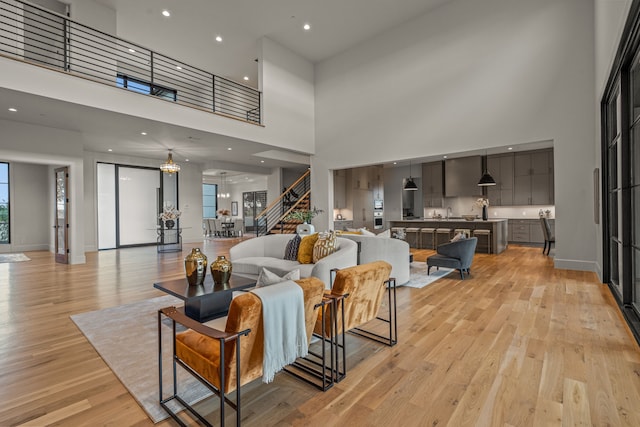 living room featuring light wood-type flooring and a high ceiling