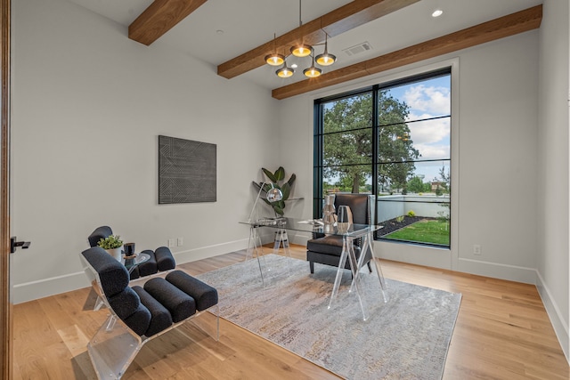 living area with beamed ceiling and light hardwood / wood-style flooring