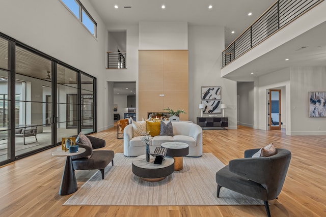 living room with light hardwood / wood-style flooring and a towering ceiling