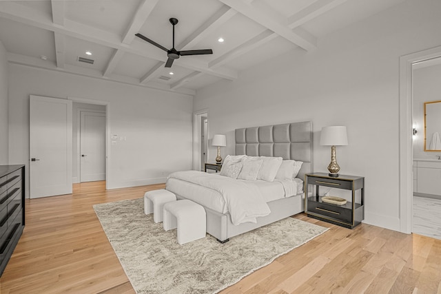 bedroom featuring coffered ceiling, light hardwood / wood-style flooring, ceiling fan, connected bathroom, and beam ceiling