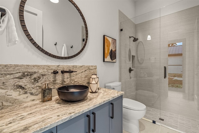 full bathroom with toilet, vanity, and a stall shower