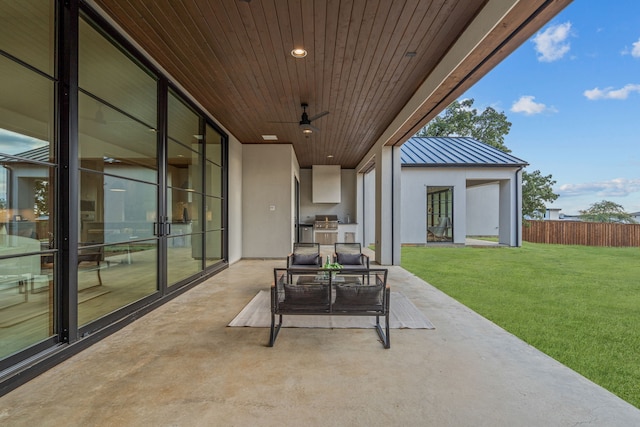 view of patio featuring fence, ceiling fan, an outdoor kitchen, and outdoor lounge area