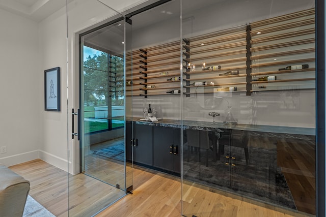 wine area featuring bar and hardwood / wood-style flooring