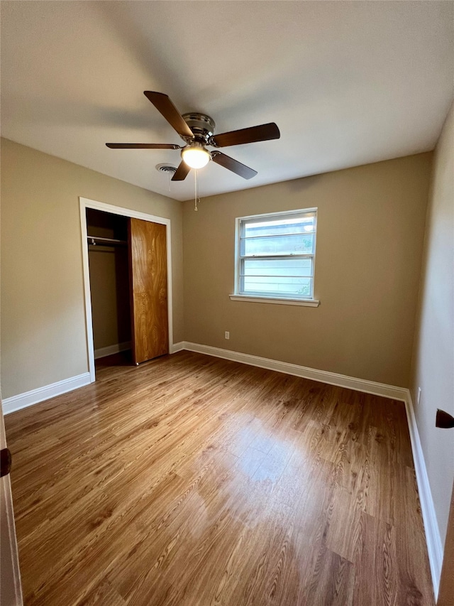 unfurnished bedroom featuring a closet, light wood-type flooring, and ceiling fan