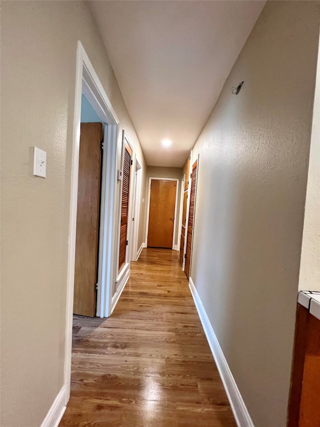 hallway with light hardwood / wood-style flooring