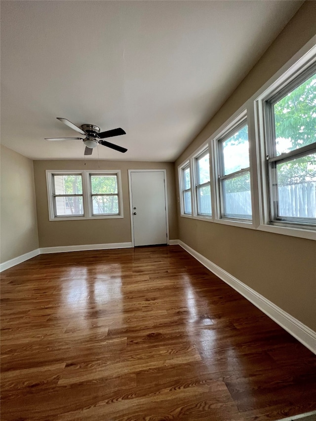 unfurnished room featuring dark wood-type flooring and ceiling fan