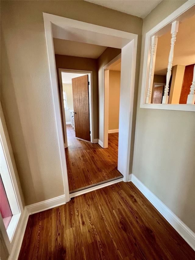 hallway with hardwood / wood-style flooring