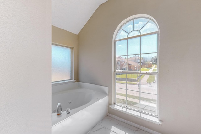 bathroom featuring a bath and vaulted ceiling