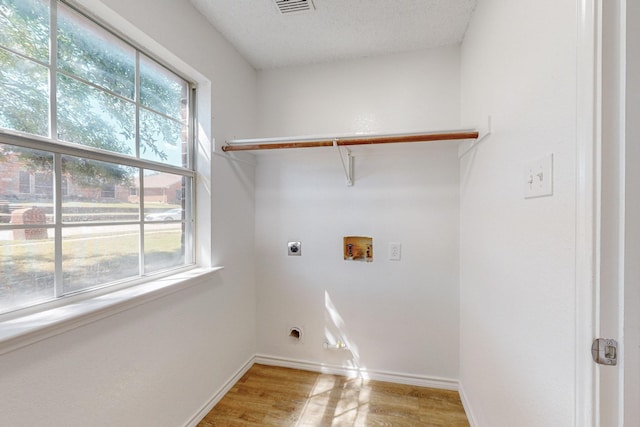 laundry room with hookup for an electric dryer, hookup for a washing machine, hardwood / wood-style flooring, and a healthy amount of sunlight