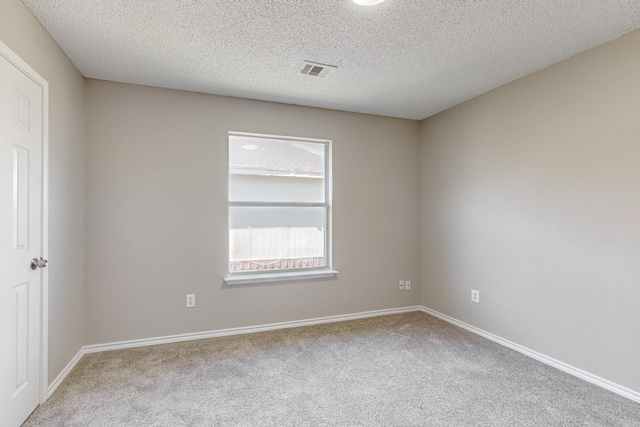 carpeted empty room with a textured ceiling