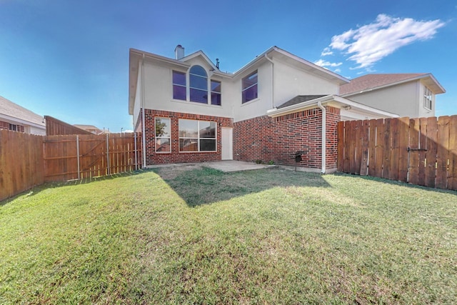 rear view of house with a yard and a patio